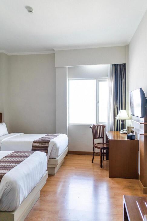 Image de la chambre d'hôtel montrant un lit et un bureau